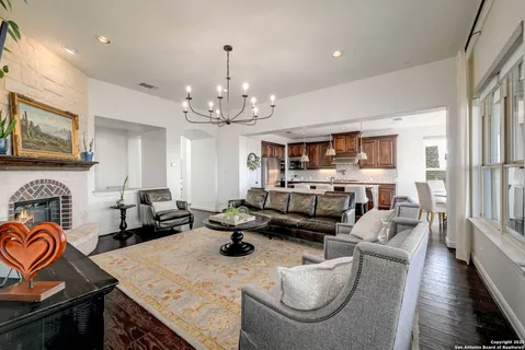 a living room with furniture kitchen view and a chandelier