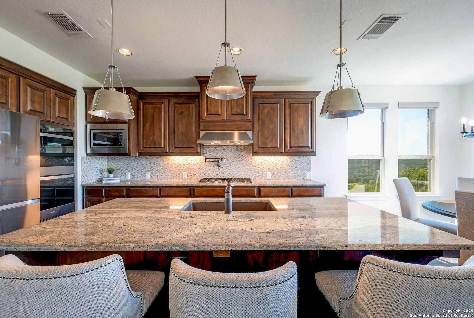 17023 Turin Ridge San Antonio, TX 78255 - Photo 14 of 48 a kitchen with granite countertop a sink a counter space cabinets and stainless steel appliances