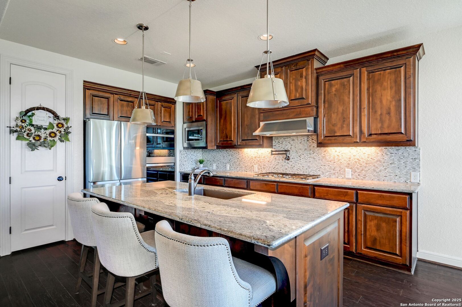 17023 Turin Ridge San Antonio, TX 78255 - Photo 15 of 48 a kitchen with granite countertop a table chairs microwave and cabinets