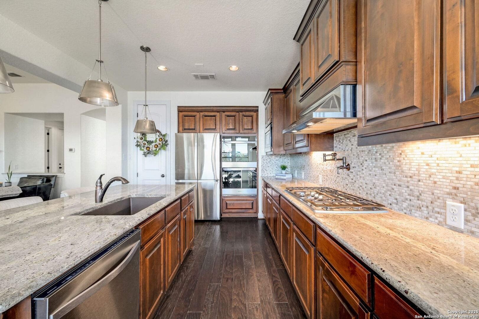 17023 Turin Ridge San Antonio, TX 78255 - Photo 17 of 48 a kitchen with granite countertop a sink a counter space appliances and cabinets