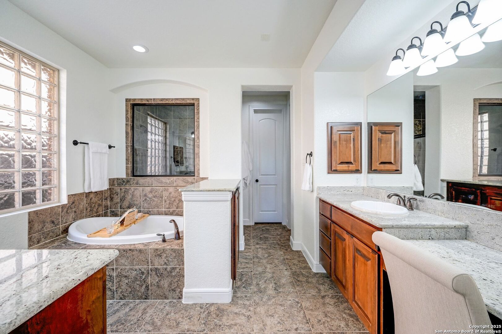 17023 Turin Ridge San Antonio, TX 78255 - Photo 25 of 48 a spacious bathroom with a granite countertop double sink and a mirror