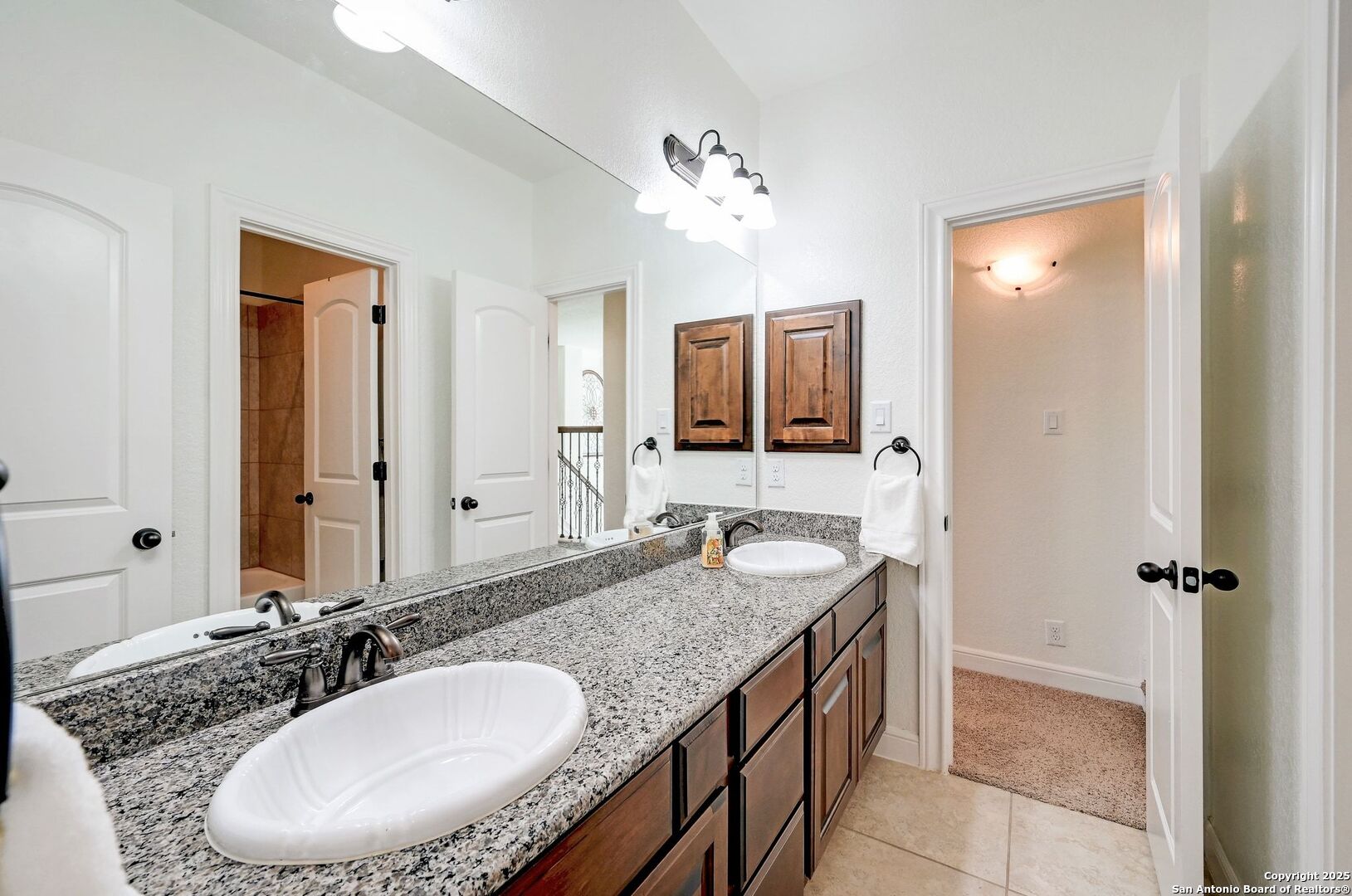 17023 Turin Ridge San Antonio, TX 78255 - Photo 37 of 48 a bathroom with a granite countertop sink a mirror and a shower