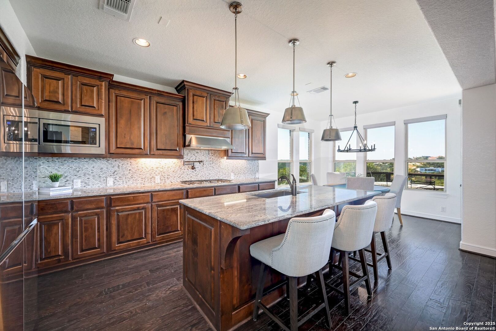 17023 Turin Ridge San Antonio, TX 78255 - Photo 10 of 48 a kitchen with stainless steel appliances granite countertop a kitchen island hardwood floor sink and stove
