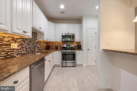 a kitchen with granite countertop a stove and a sink