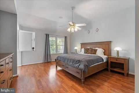 a bedroom with a large bed chandelier and a window
