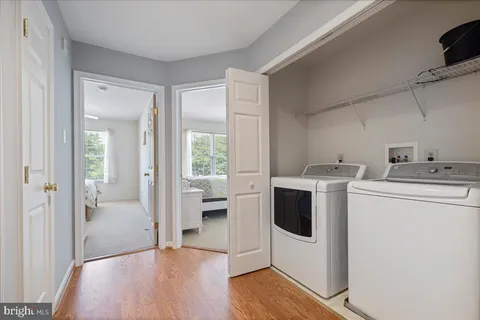 a view of washer and dryer with bathroom in the background