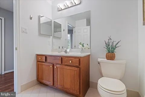 a bathroom with a toilet a sink a vanity and mirror