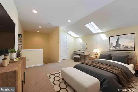 a large bedroom with a bed and a flat screen tv