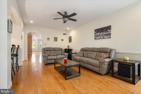 a living room with furniture kitchen view and a chandelier