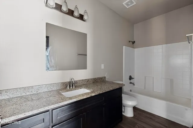 a bathroom with a granite countertop sink and a mirror