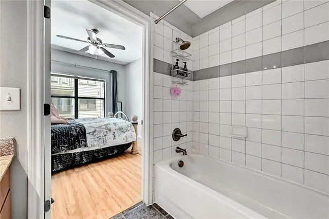a bathroom with a tub sink shower and a mirror