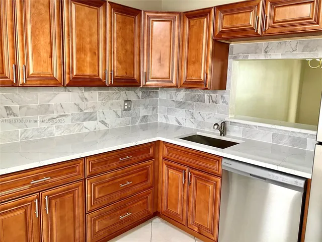 a kitchen with stainless steel appliances granite countertop wooden cabinets a sink and dishwasher