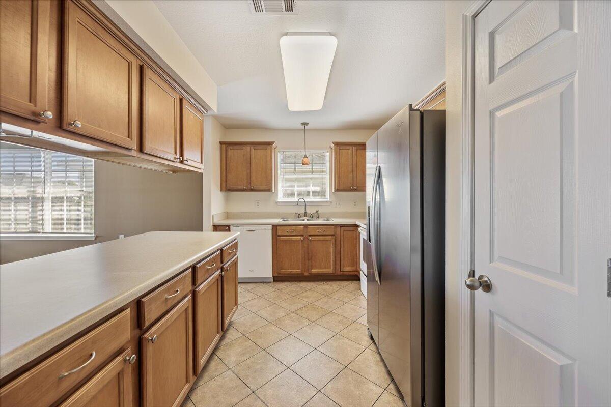 5414 Fawn Ridge Drive Gulf Breeze, FL 32563 - Photo 11 of 31 a kitchen with stainless steel appliances a refrigerator sink and cabinets