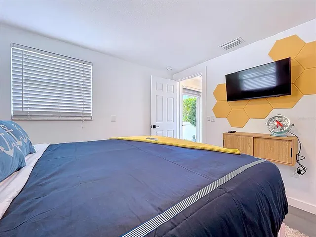 a bedroom with a bed and a flat screen tv