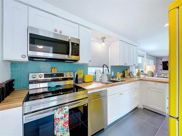 a view of kitchen with stainless steel appliances granite countertop a sink and a refrigerator