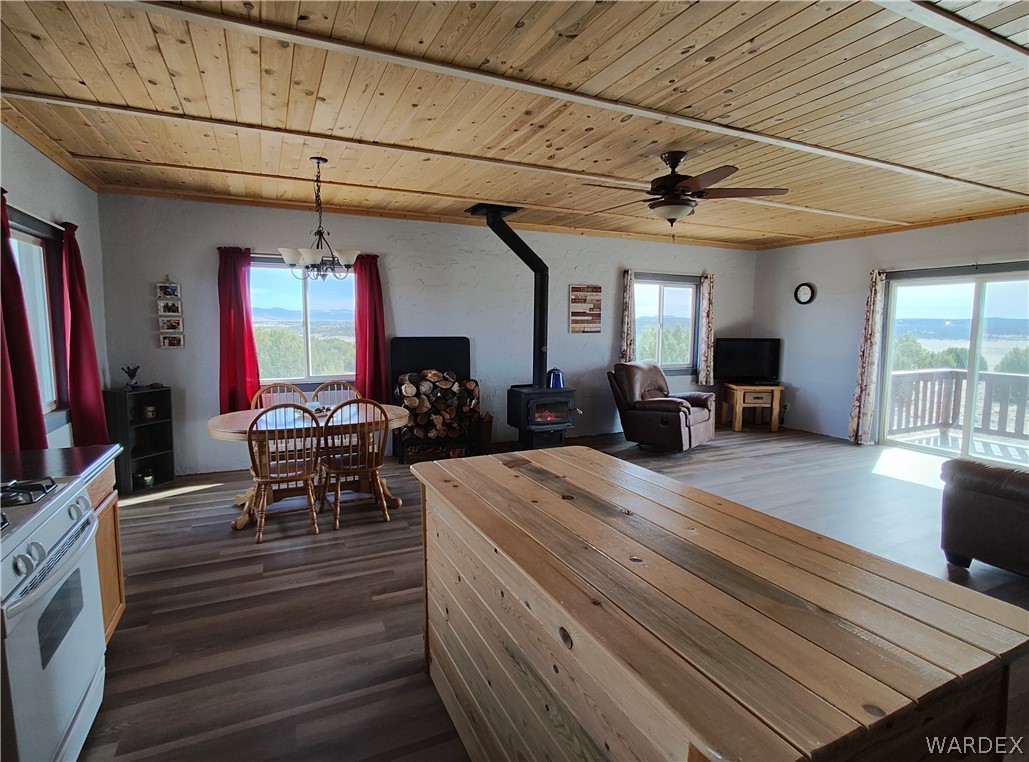 15 County Road Concho, AZ 85924 - Photo 21 of 93 Open concept living space featuring wood-finish flooring, a wood-paneled ceiling, and a wood-burning stove