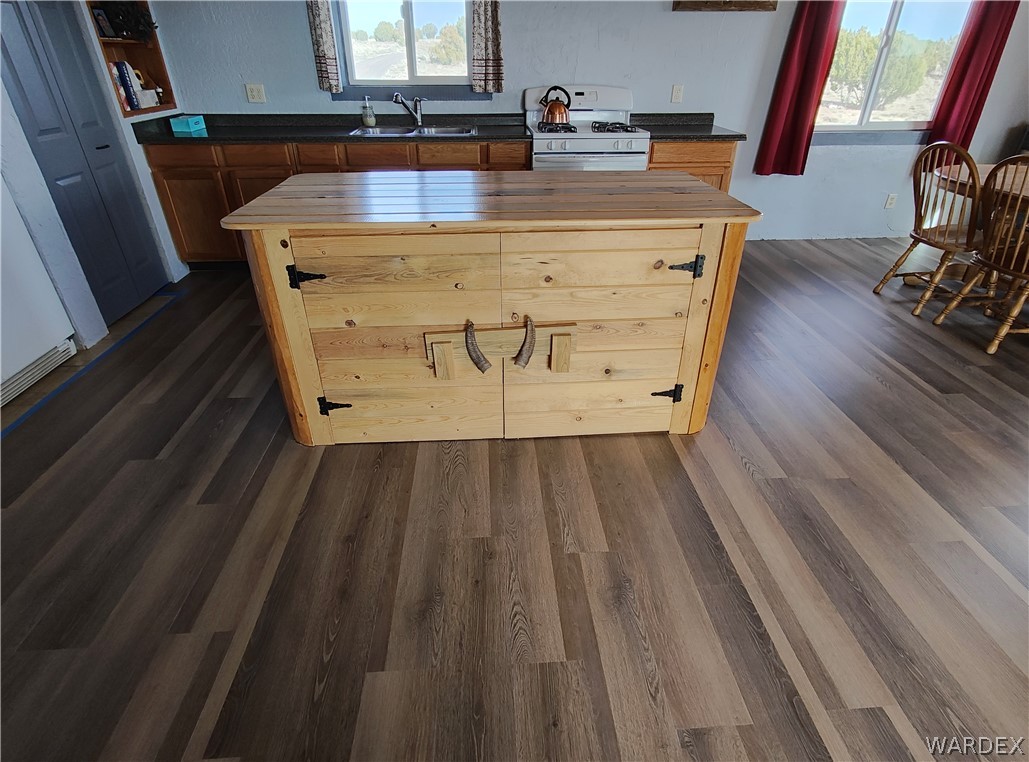 15 County Road Concho, AZ 85924 - Photo 22 of 93 Kitchen featuring a central wood island with decorative hardware, rich wood-finish flooring, and dark countertops