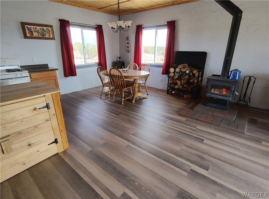15 County Road Concho, AZ 85924 - Photo 24 of 93 Open concept living area featuring wood-finish flooring, a wood-burning stove on a brick hearth, and a wood plank ceiling