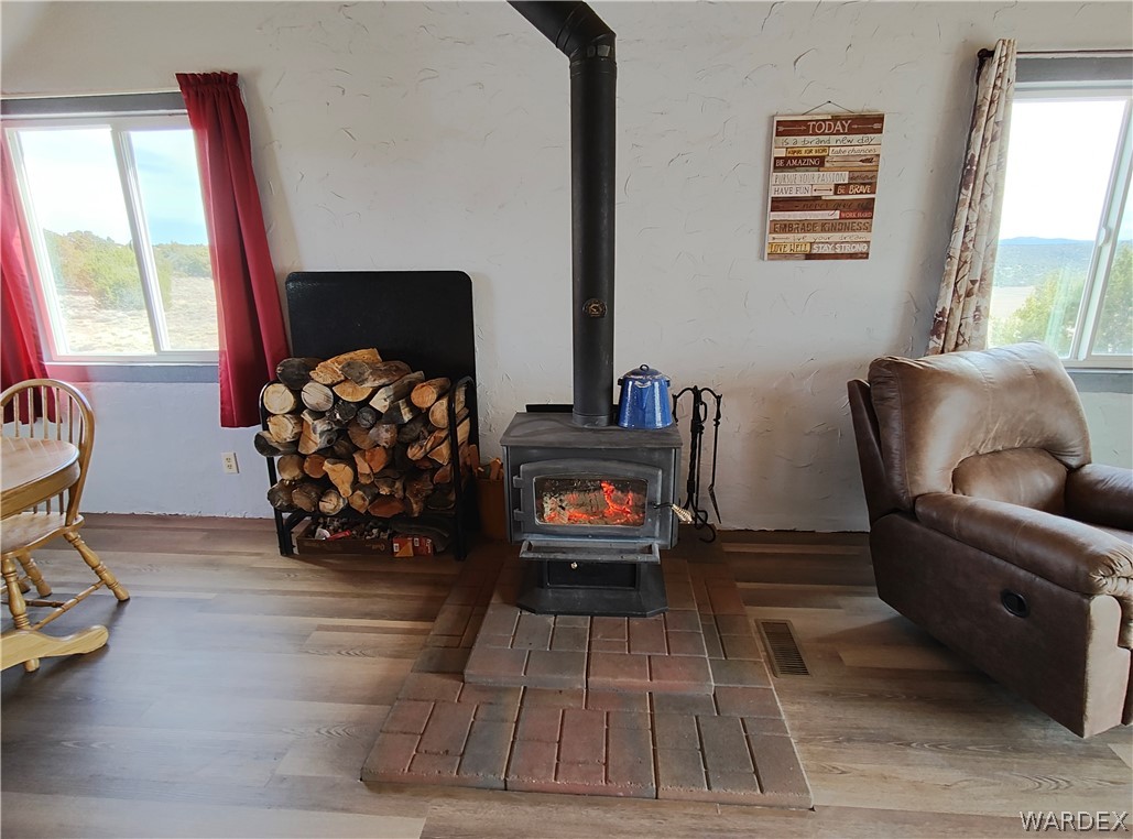 15 County Road Concho, AZ 85924 - Photo 27 of 93 Wood-finish flooring throughout, featuring a cast iron wood-burning stove with a brick-patterned hearth
