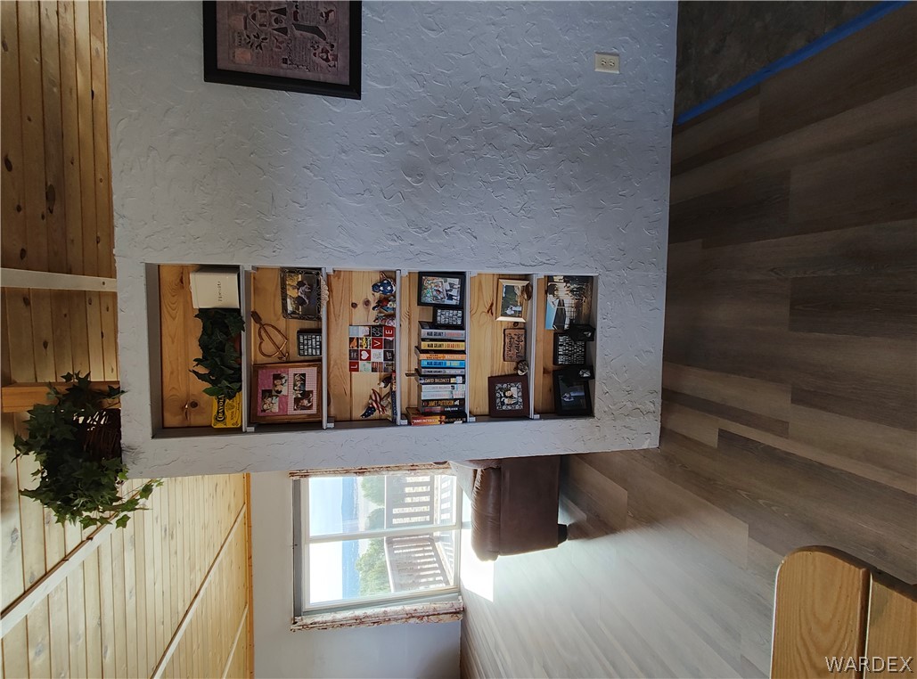 15 County Road Concho, AZ 85924 - Photo 28 of 93 Built-in shelving unit with natural wood backing, textured wall finish, wood-finish flooring, wood plank ceiling, and sliding glass doors opening to an outdoor deck