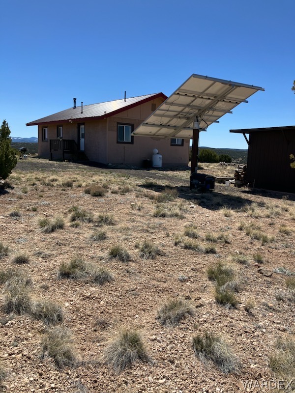 15 County Road Concho, AZ 85924 - Photo 32 of 93 Exterior featuring a metal roof, light-colored siding, and a deck at the rear entry