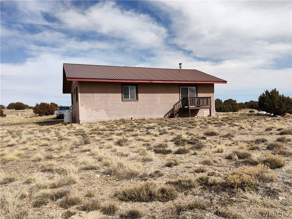 15 County Road Concho, AZ 85924 - Photo 45 of 93 Single-story residence featuring a brown metal roof, light-colored exterior siding, and a wooden deck with railing