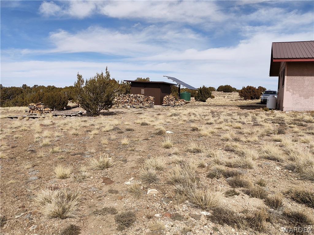 15 County Road Concho, AZ 85924 - Photo 48 of 93 Expansive outdoor space featuring a detached storage shed, solar panels, and a brown metal-roofed structure