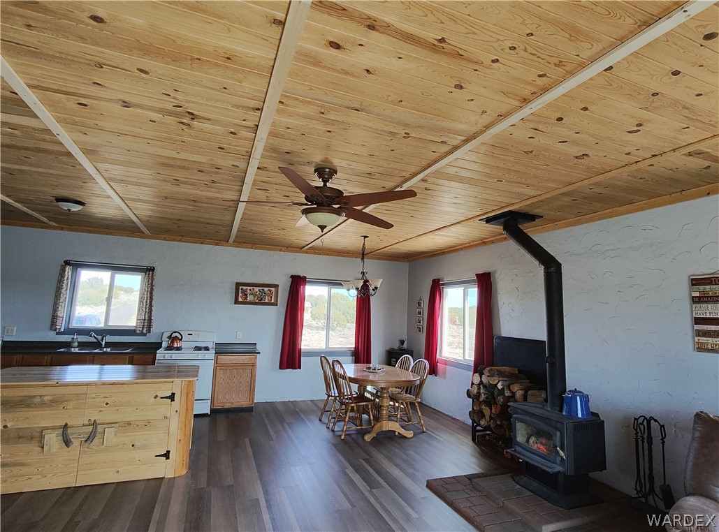 15 County Road Concho, AZ 85924 - Photo 73 of 93 Open-concept living area featuring wood-finish flooring, a wood plank ceiling, and a wood-burning stove with brick hearth