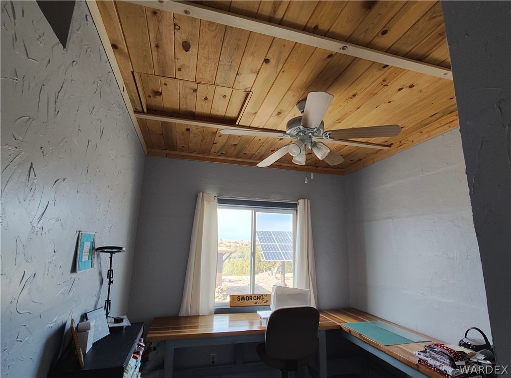 15 County Road Concho, AZ 85924 - Photo 9 of 93 Room featuring a wood plank ceiling, textured gray walls, and a multi-blade ceiling fan with integrated lighting