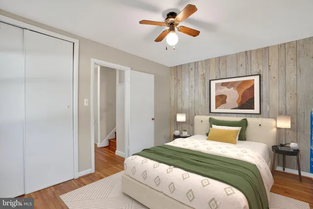 a view of a workspace with furniture a ceiling fan and wooden floor