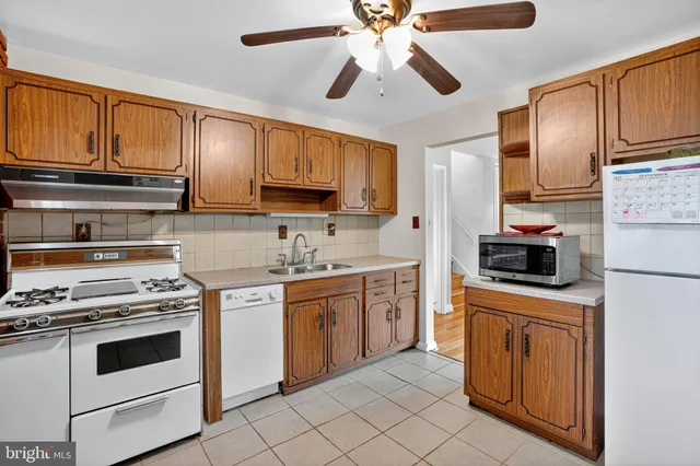 a kitchen with stainless steel appliances granite countertop a sink a stove cabinets and entryway