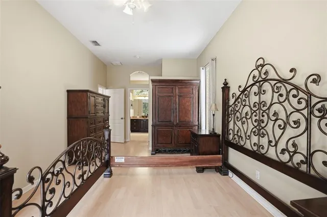 an empty room with a chandelier fan and windows