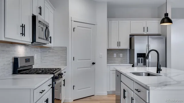 a kitchen with stainless steel appliances granite countertop a sink stove and cabinets