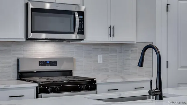 a kitchen with stainless steel appliances a stove and a microwave