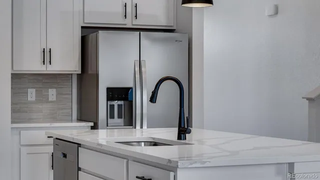 a kitchen with a granite countertop white cabinets and a sink