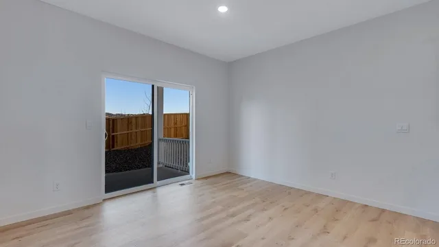 an empty room with wooden floor and cabinet