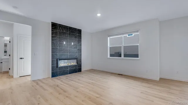 a view of empty room with front door and wooden floor