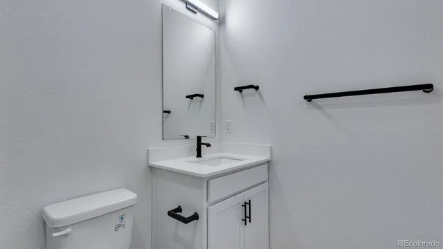 a bathroom with a sink a toilet and a mirror