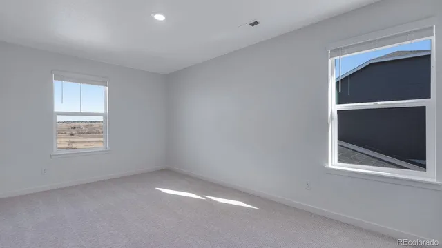 a view of an empty room with a window and closet