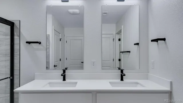 a bathroom with double vanity sink and a mirror