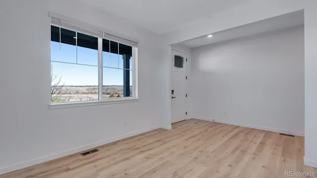 a view of empty room with wooden floor and windows