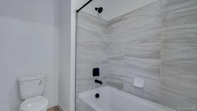 a bathroom with a toilet and a shower