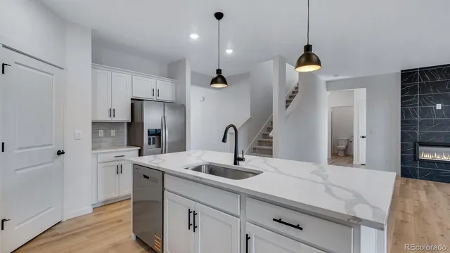 a kitchen with kitchen island a sink stainless steel appliances and cabinets