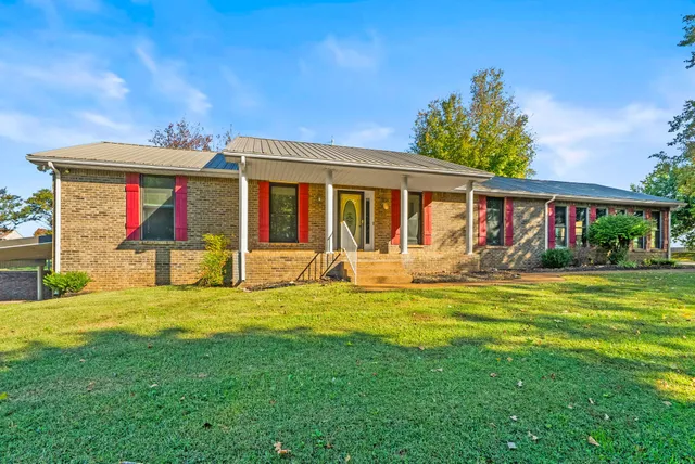 a view of a house with a yard patio and swimming pool