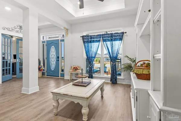 a hallway with white cabinets and wooden floor