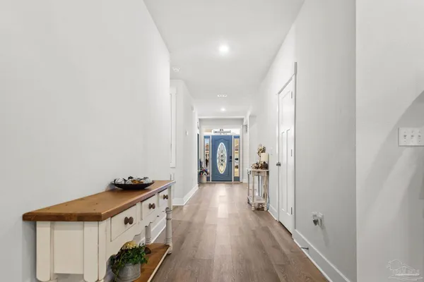 a view of a hallway with wooden floor and furniture