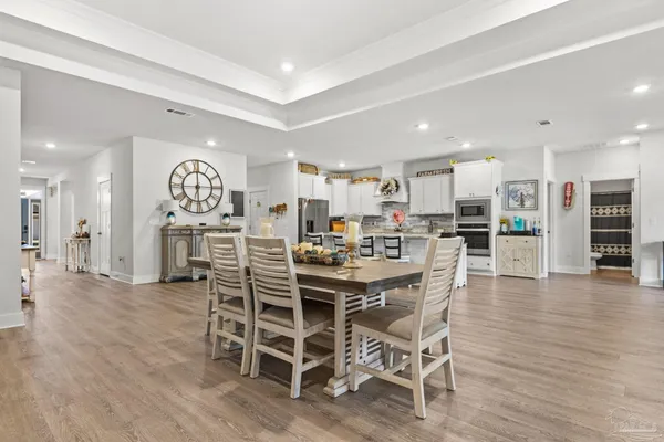 a kitchen with stainless steel appliances a stove a kitchen island a hardwood floor and a sink
