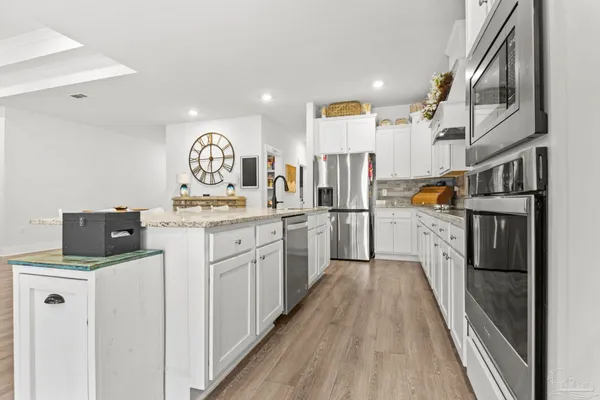 a kitchen with granite countertop a sink a stove and cabinets