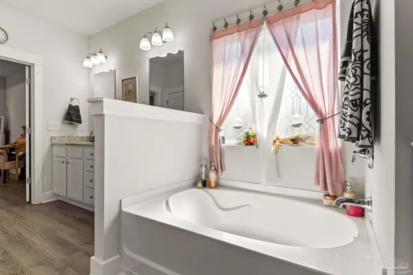 a bedroom with a bed and dresser with mirror