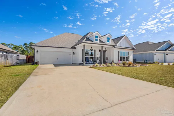 a front view of a house with a garden and yard